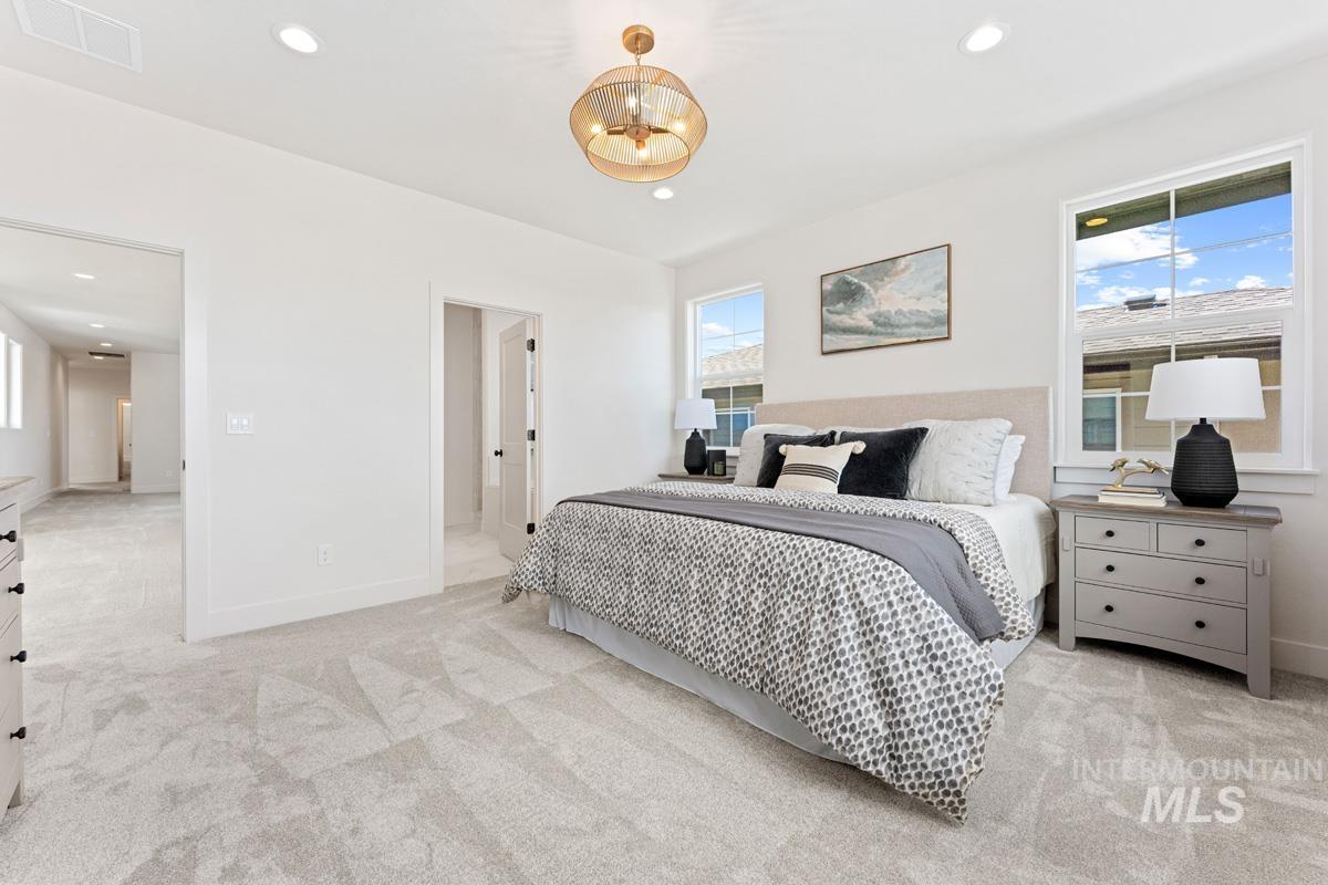 13374 North Spring Creek Way Boise, ID 83714 - Photo 15 of 49 Bedroom featuring light colored carpet, suspended lighting, and ensuite bath