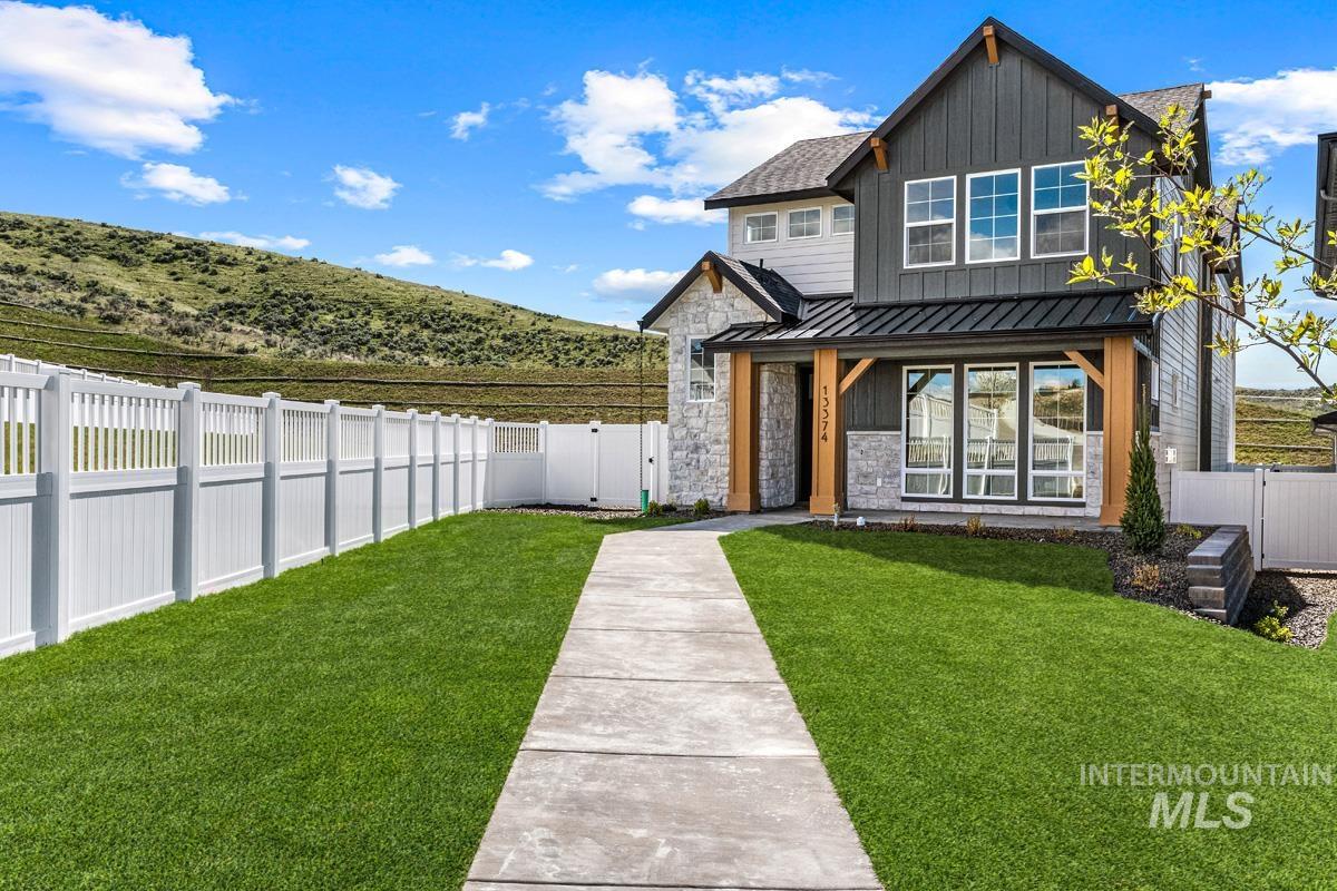 13374 North Spring Creek Way Boise, ID 83714 - Photo 2 of 49 View of front of home featuring a standing seam roof, stone siding, a gate, and board and batten siding