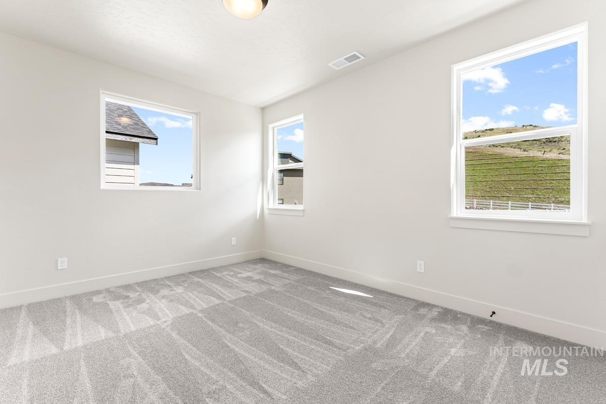 13374 North Spring Creek Way Boise, ID 83714 - Photo 24 of 49 Spare room with light carpet and baseboards