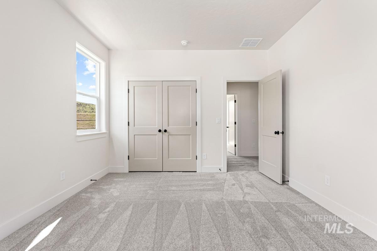 13374 North Spring Creek Way Boise, ID 83714 - Photo 25 of 49 Unfurnished bedroom featuring light carpet and a closet