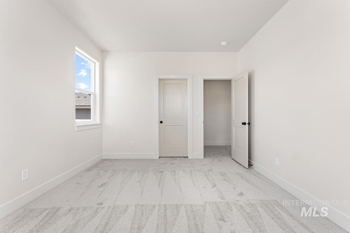 13374 North Spring Creek Way Boise, ID 83714 - Photo 28 of 49 Unfurnished bedroom with light carpet and baseboards