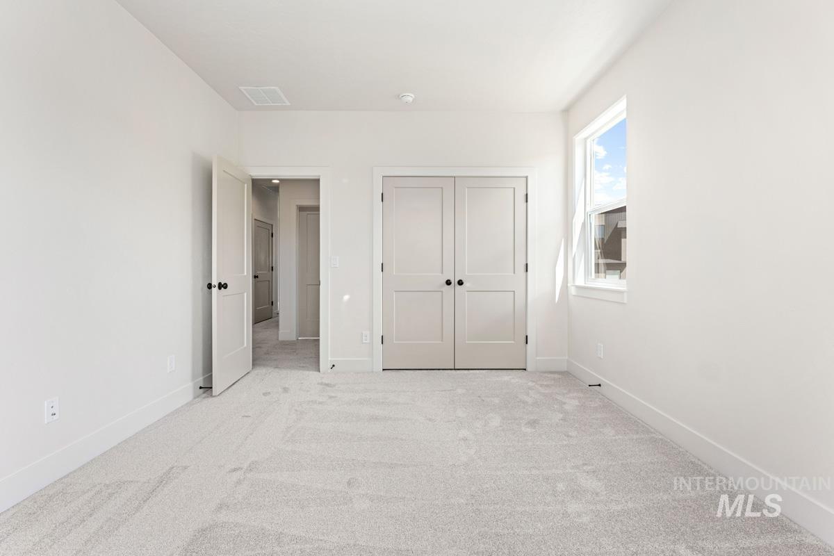 13374 North Spring Creek Way Boise, ID 83714 - Photo 31 of 49 Unfurnished bedroom featuring light carpet and a closet
