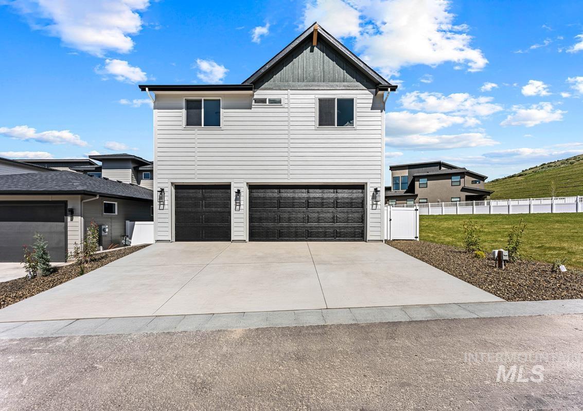 13374 North Spring Creek Way Boise, ID 83714 - Photo 37 of 49 View of front of house featuring board and batten siding, a garage, and driveway
