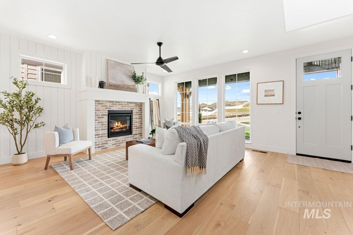13374 North Spring Creek Way Boise, ID 83714 - Photo 6 of 49 Living area featuring light wood-style flooring, a ceiling fan, a brick fireplace, and recessed lighting
