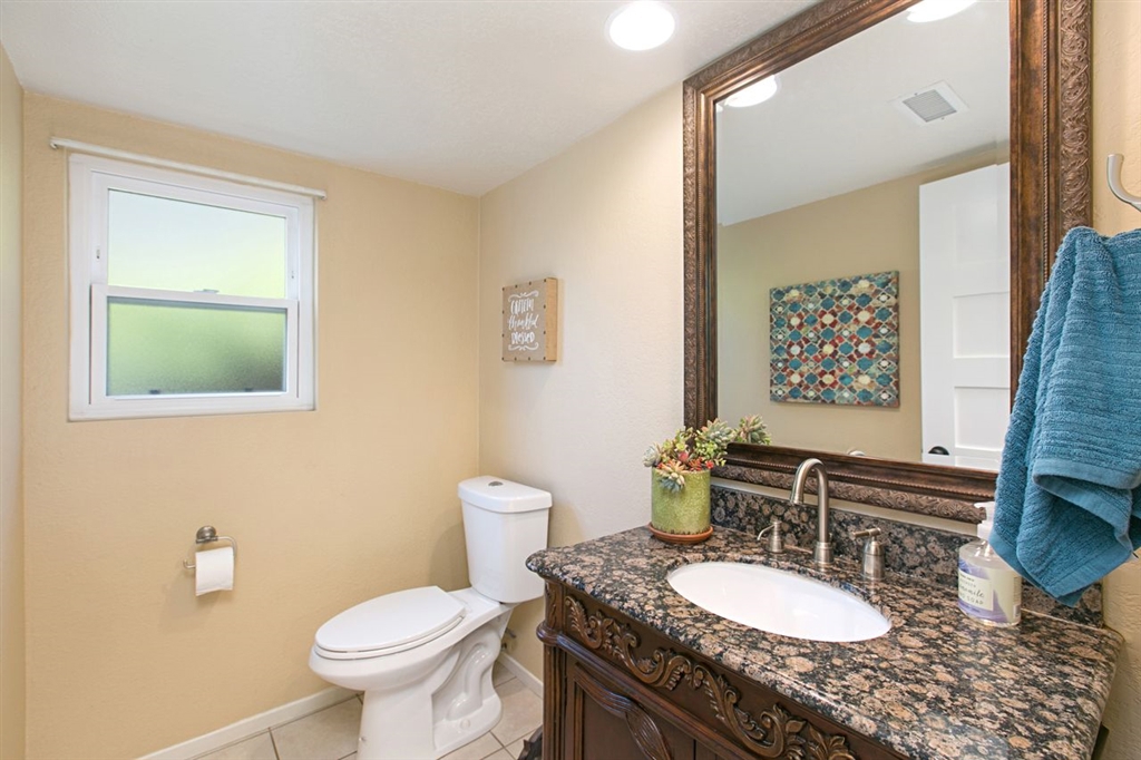 519 Gardendale Road Encinitas, CA 92024 - Photo 12 of 25 a bathroom with a granite countertop toilet a sink and a mirror
