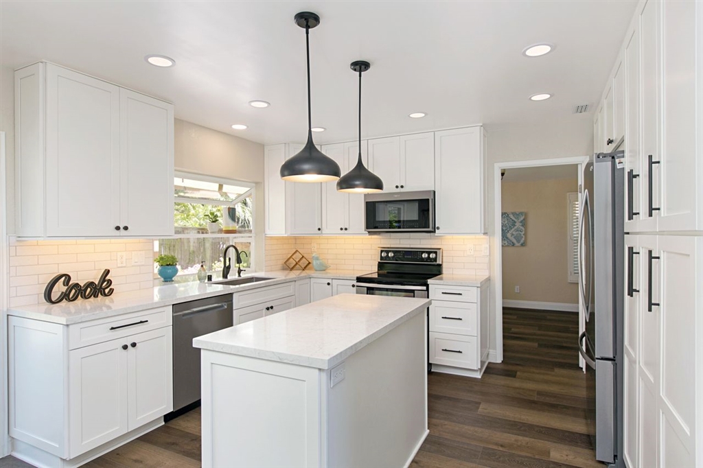 519 Gardendale Road Encinitas, CA 92024 - Photo 8 of 25 a kitchen with white cabinets and stainless steel appliances