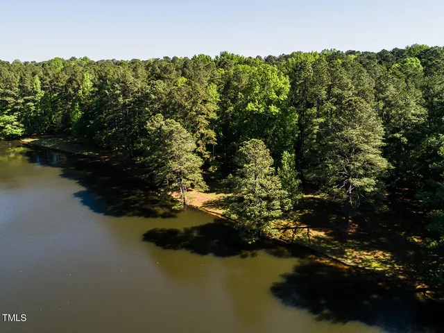 an aerial view of a house with a yard and lake view