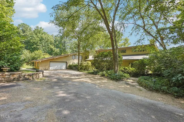 a kitchen with stainless steel appliances kitchen island granite countertop a table chairs in it and wooden floors