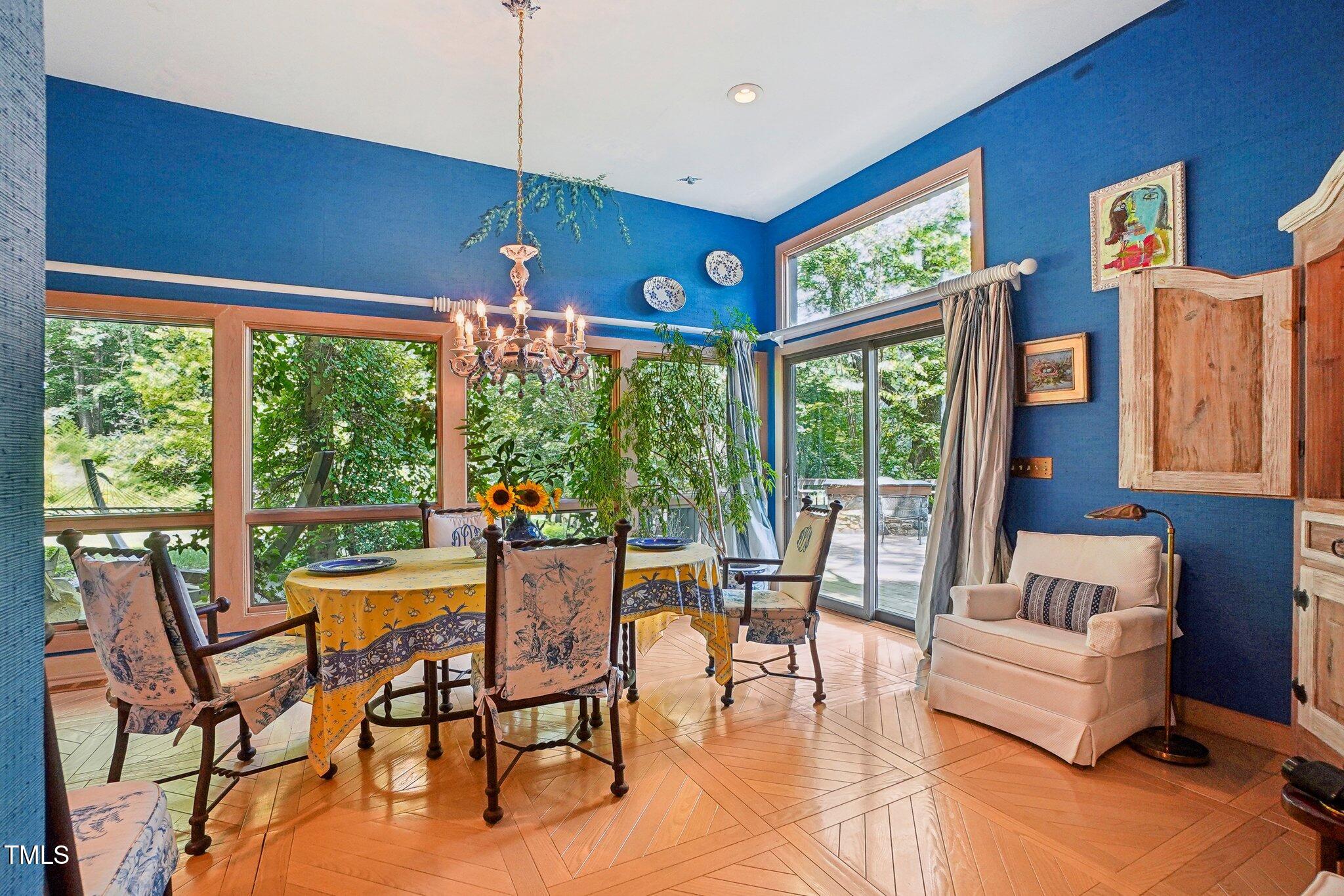 10305 Old Creedmoor Road Raleigh, NC 27613 - Photo 42 of 63 a dining room with furniture large windows and wooden floor