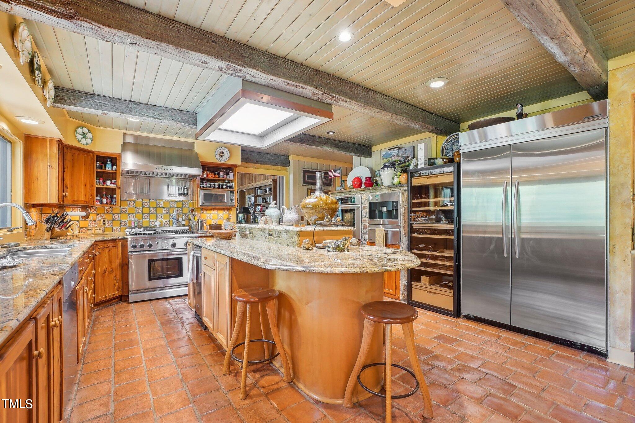10305 Old Creedmoor Road Raleigh, NC 27613 - Photo 44 of 63 a kitchen with stainless steel appliances kitchen island granite countertop a table chairs in it and wooden floors
