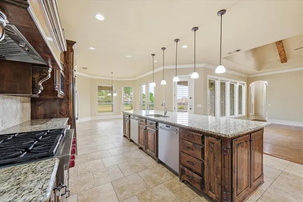 a kitchen with stainless steel appliances granite countertop a stove a sink and a refrigerator