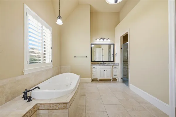 a bathroom with a tub sink and mirror