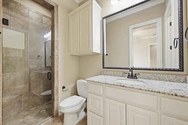 a bathroom with a granite countertop sink toilet and shower