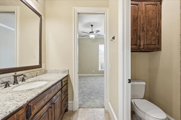 a bathroom with a granite countertop sink a toilet and shower