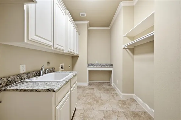 a bathroom with a granite countertop sink and white cabinets