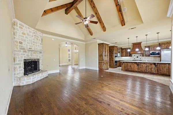 a view of a big room with wooden floor a fireplace and windows