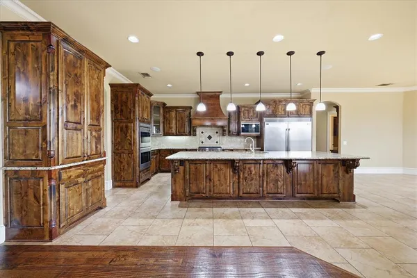 a kitchen with stainless steel appliances granite countertop a refrigerator a sink and a stove