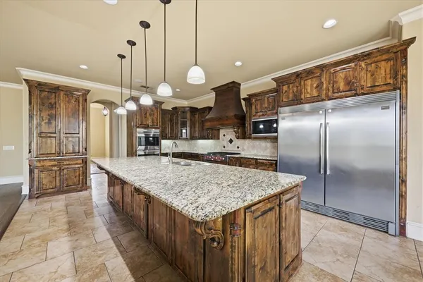 a kitchen with stainless steel appliances granite countertop a kitchen island a stove and a sink