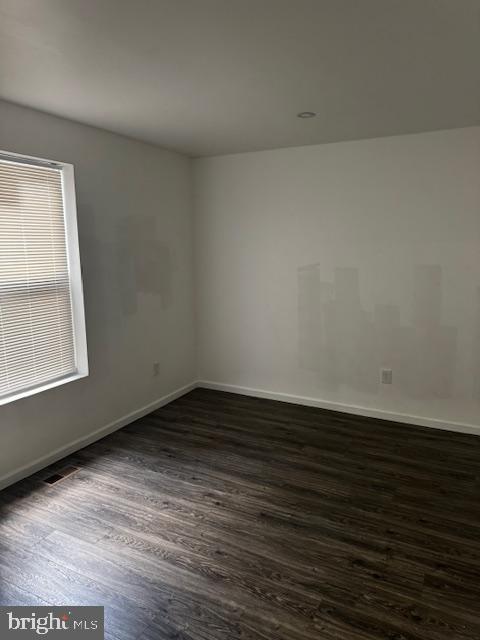 1339 West Lafayette Avenue, Unit 1 Baltimore, MD 21217 - Photo 15 of 24 a view of an empty room with wooden floor and a window