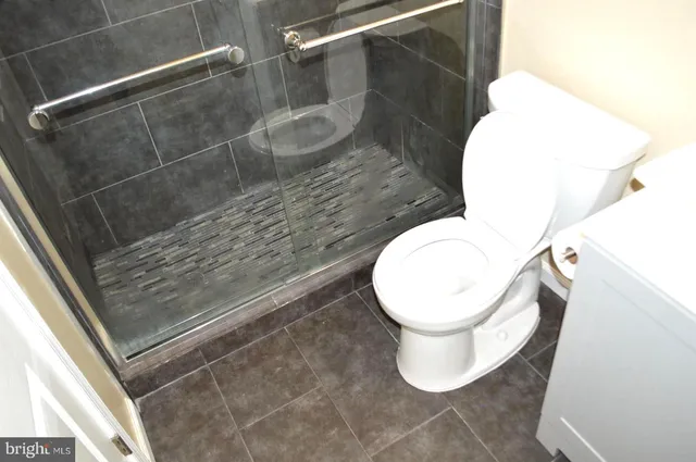 a white toilet sitting next to a shower