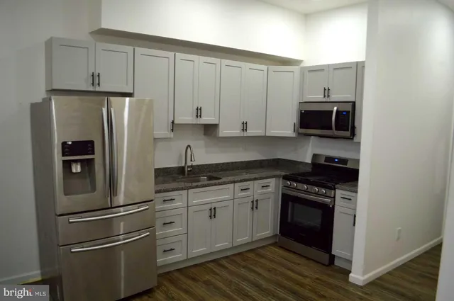 a kitchen with stainless steel appliances a refrigerator and a stove top oven