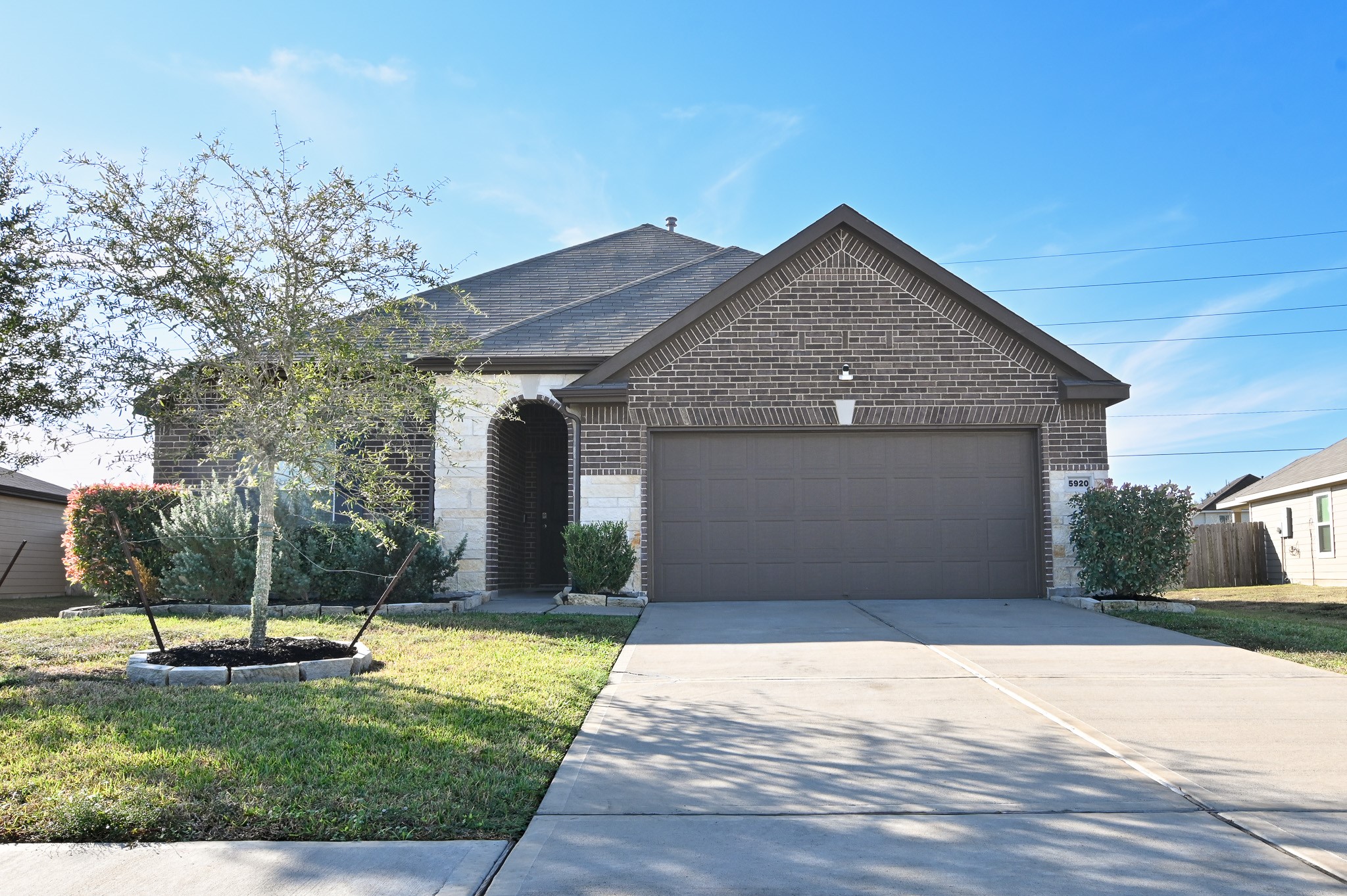 This single story brick home features a two car garage and a well-maintained front yard with minimal landscaping and a welcoming curb appeal.