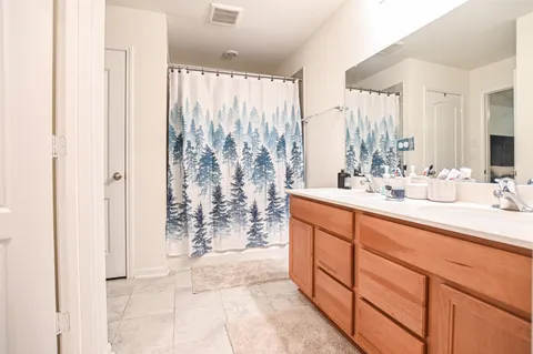 a bathroom with double vanity and a shower