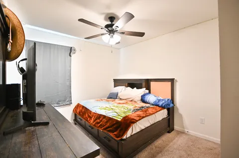 a bedroom with a large bed and a chandelier