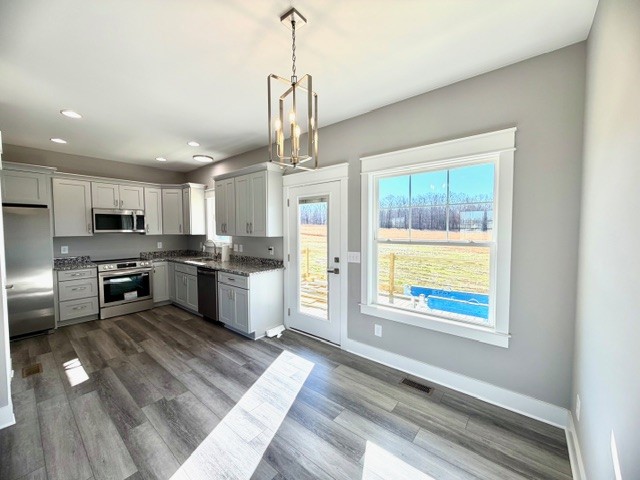 6421 Lynchburg Road Winchester, TN 37398 - Photo 9 of 25 a kitchen with stainless steel appliances granite countertop a refrigerator a stove a sink dishwasher a oven with white cabinets and wooden floor