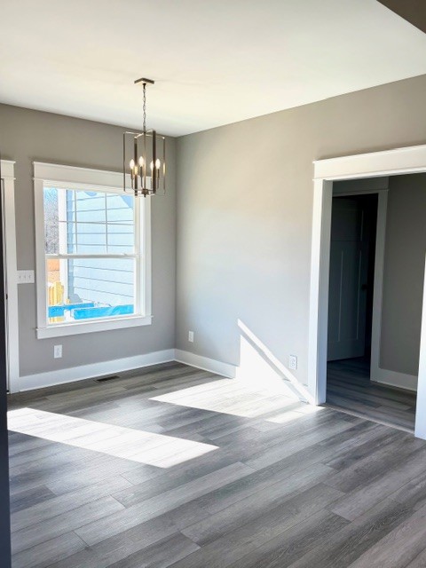 6421 Lynchburg Road Winchester, TN 37398 - Photo 10 of 25 an empty room with wooden floor chandelier and windows