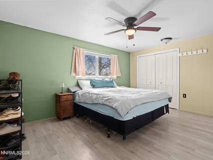 a spacious bedroom with a bed and a ceiling fan