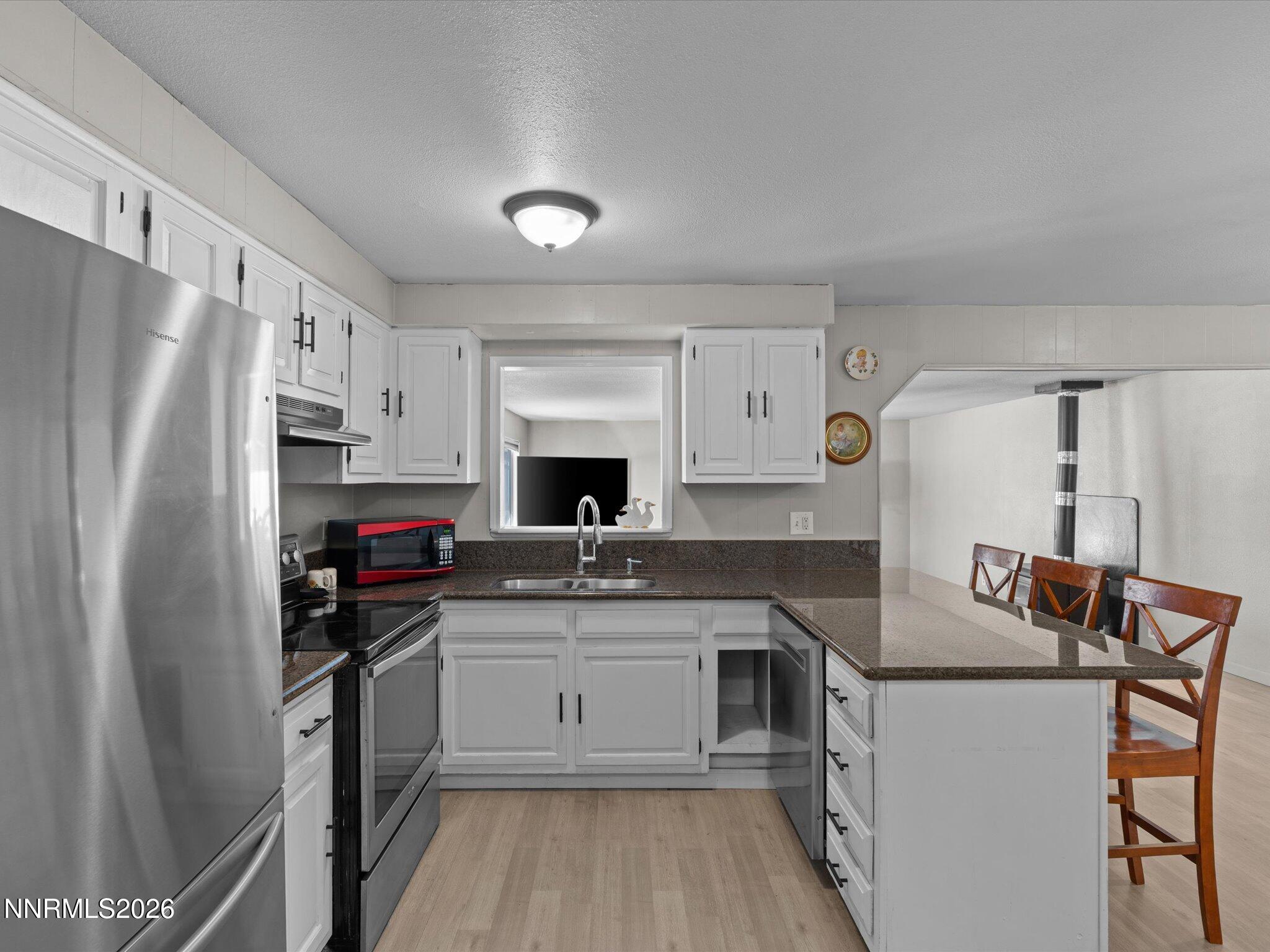 151 Roughing It Road Dayton, NV 89403 - Photo 7 of 25 a kitchen with stainless steel appliances granite countertop a sink stove refrigerator and cabinets