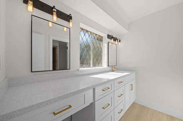 a bathroom with a granite countertop sink a toilet and a mirror