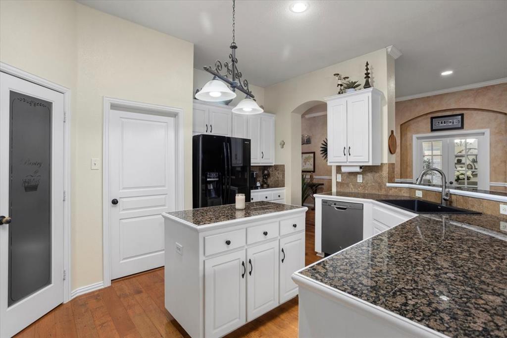 8312 Teja Trail Benbrook, TX 76126 - Photo 9 of 23 a kitchen with white cabinets and stainless steel appliances
