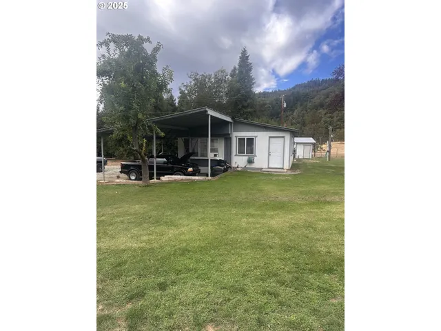 a view of a house with a yard and sitting area