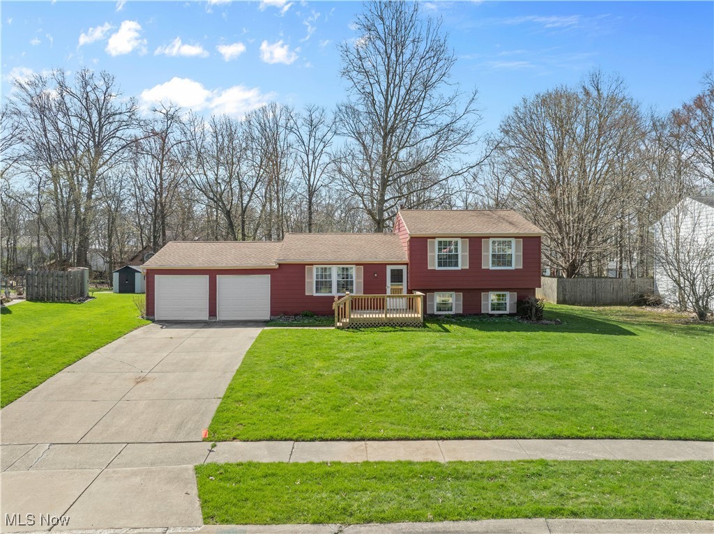 4301 Baird Road Stow, OH 44224 - Photo 1 of 50 Tri-level home featuring driveway, an attached garage, fence, a front yard, and a wooden deck