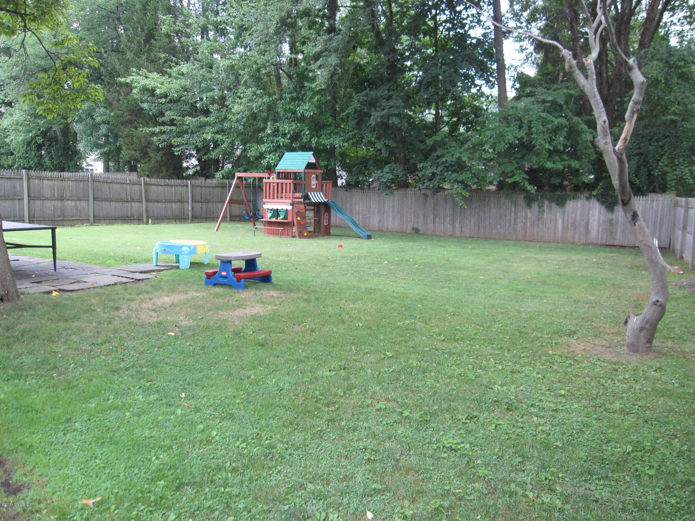84 Indian Field Road Greenwich, CT 06830 - Photo 17 of 19 a view of backyard with a slide trees and wooden fence