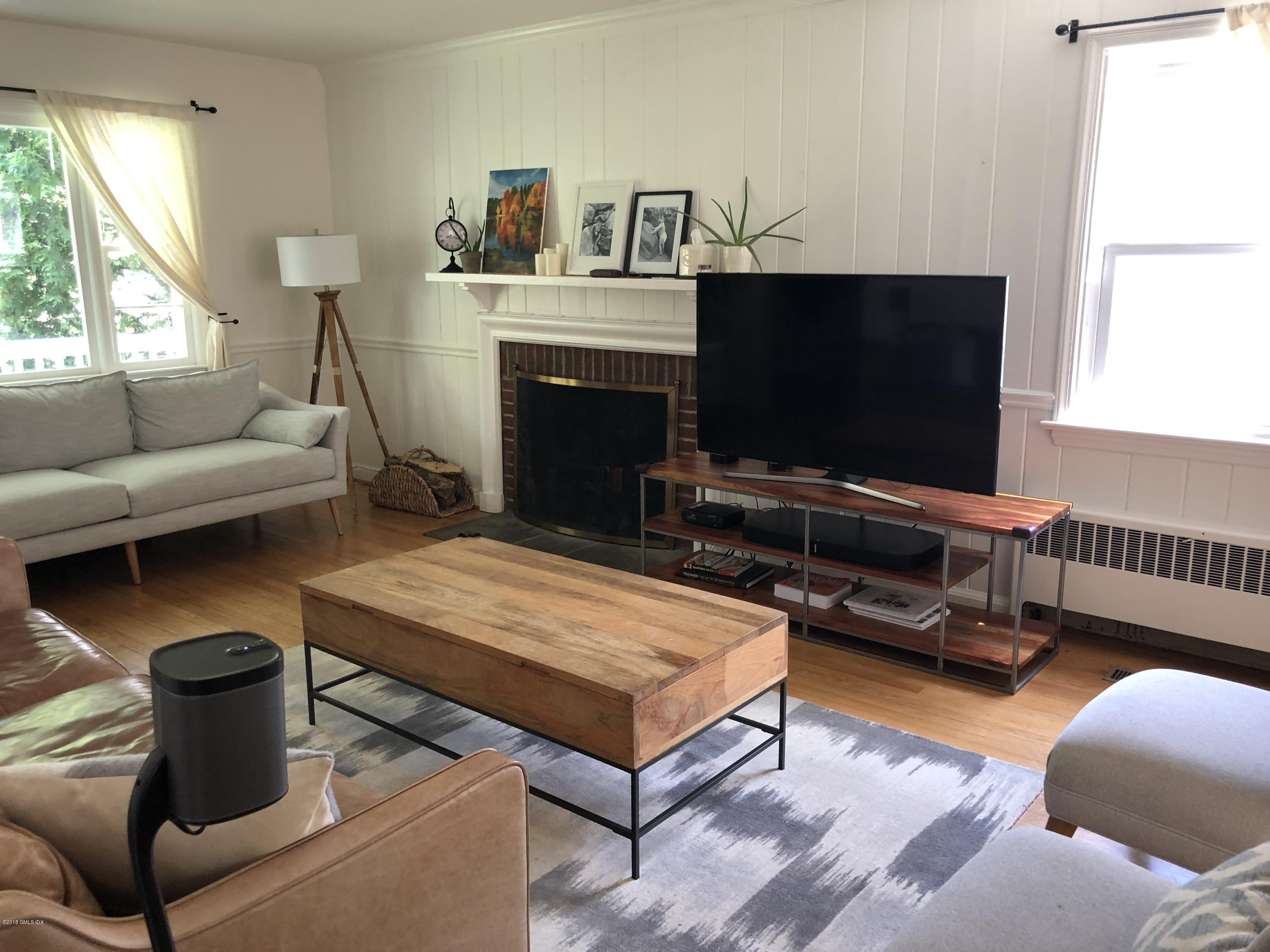 84 Indian Field Road Greenwich, CT 06830 - Photo 3 of 19 a living room with furniture a flat screen tv and a fireplace