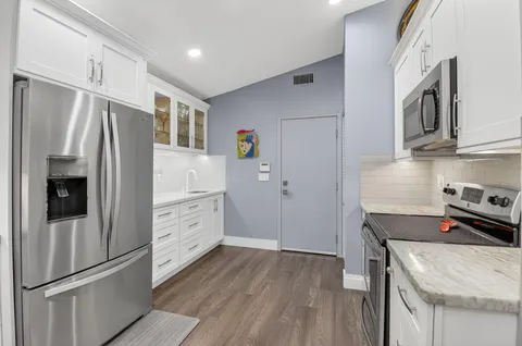 a bedroom with a bed a desk and chair with garden view