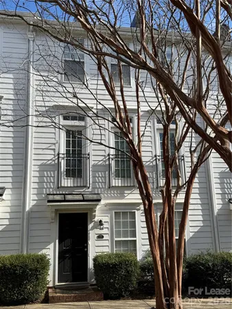 a front view of a house with a tree