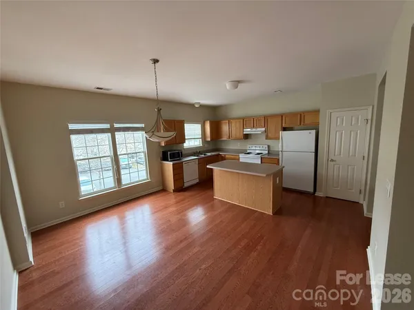 a kitchen with stainless steel appliances granite countertop a refrigerator a sink dishwasher a stove with wooden floor
