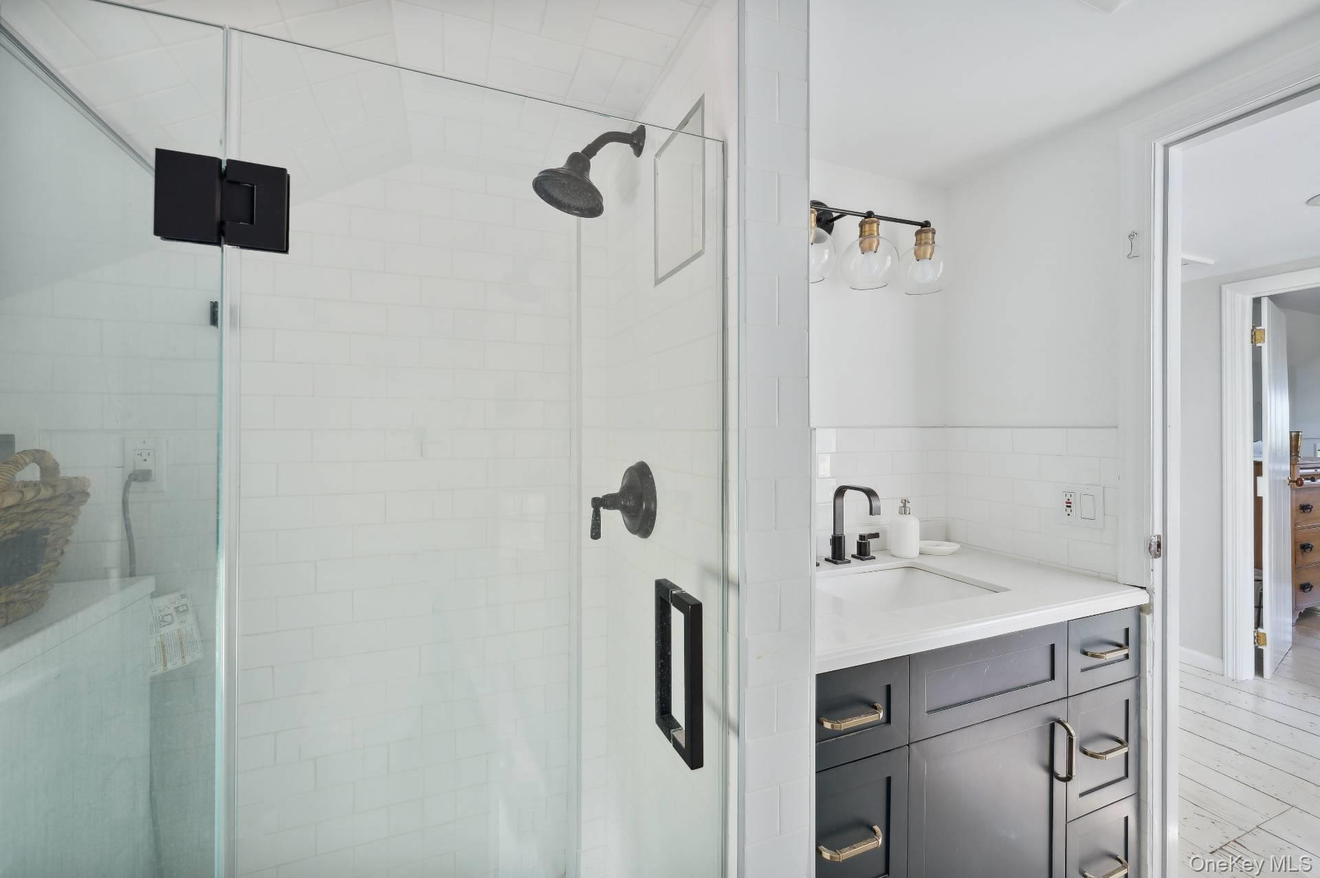 2600 Oregon Road Mattituck, NY 11952 - Photo 31 of 32 a bathroom with a sink a mirror and shower