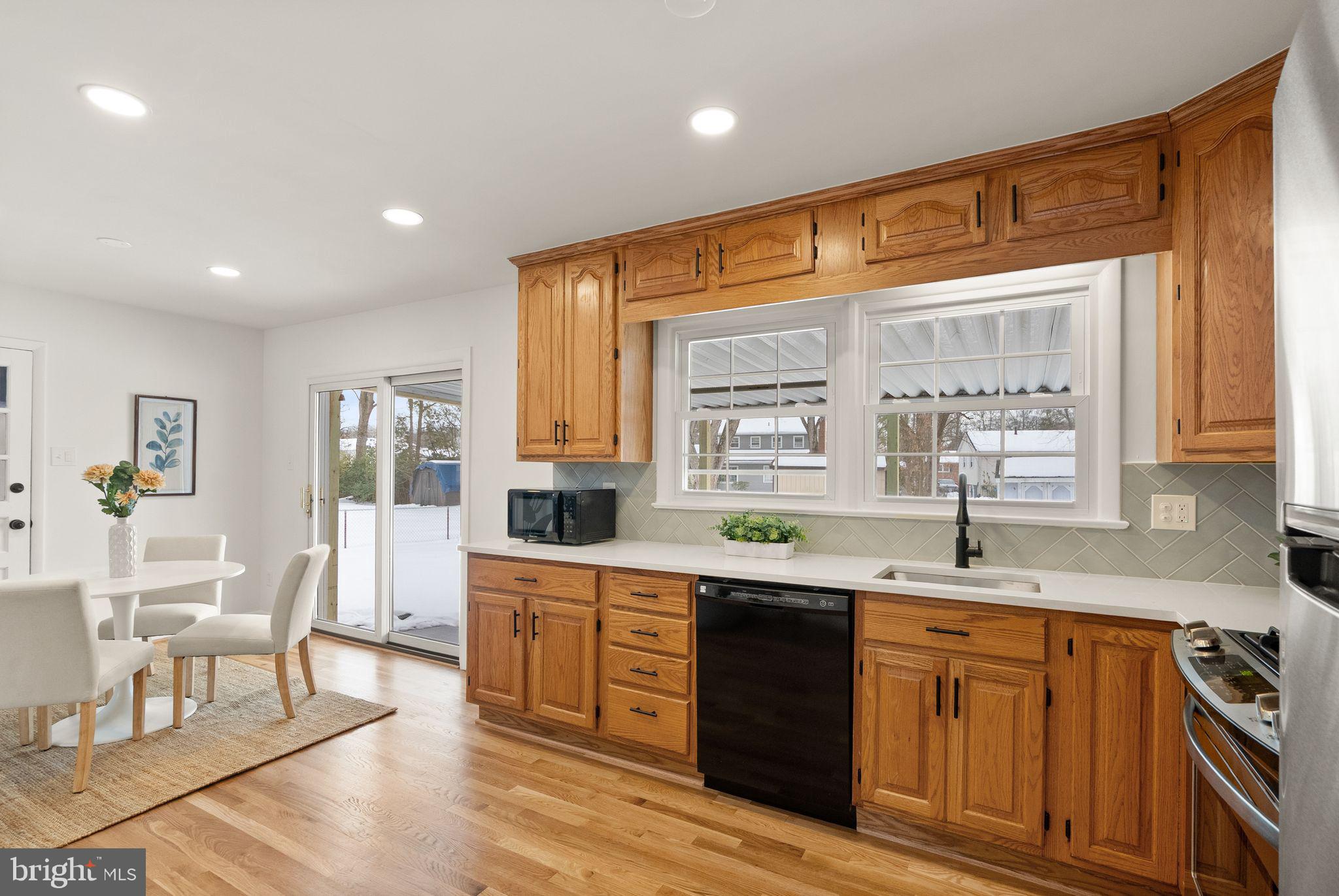 4217 Alcott Street Alexandria, VA 22309 - Photo 16 of 42 a kitchen with stainless steel appliances granite countertop wooden cabinets a sink a stove a dining table and chairs