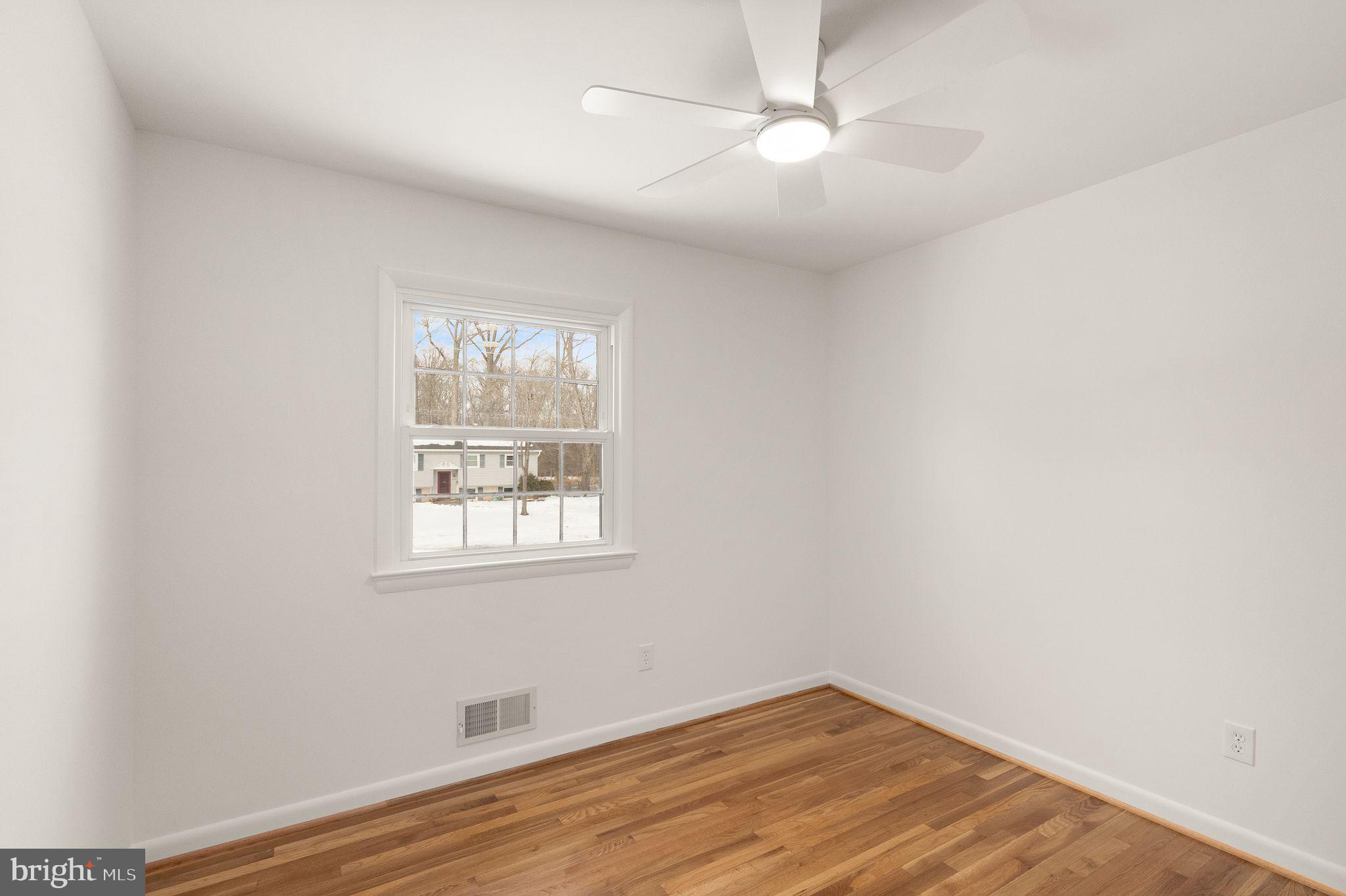 4217 Alcott Street Alexandria, VA 22309 - Photo 25 of 42 an empty room with wooden floor ceiling fan and windows