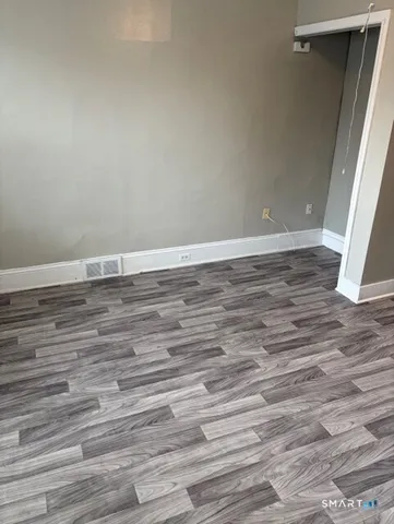 a view of a room with wooden floor