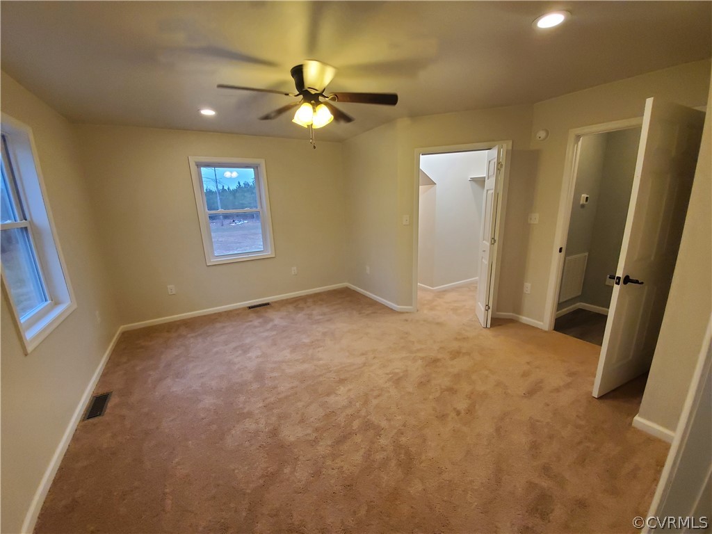 488 Guinea Road Farmville, VA 23901 - Photo 11 of 22 an empty room with a chandelier fan and windows