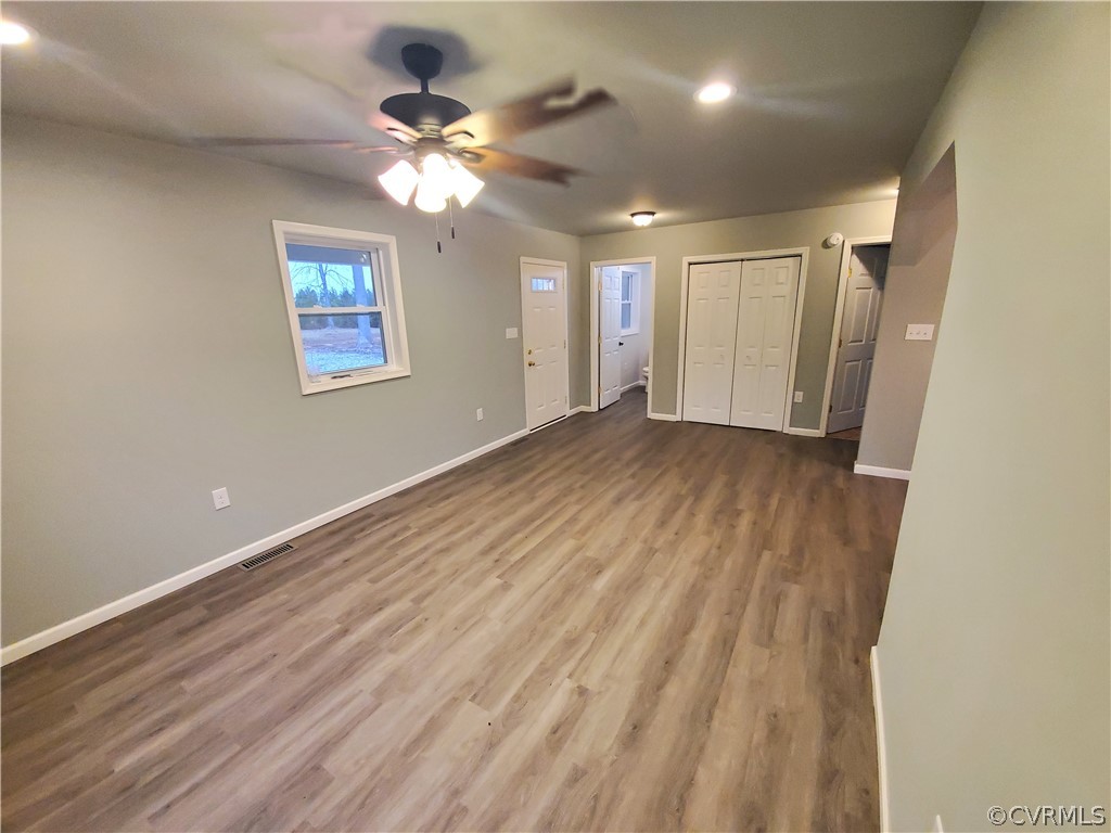 488 Guinea Road Farmville, VA 23901 - Photo 2 of 22 an empty room with wooden floor fan and windows