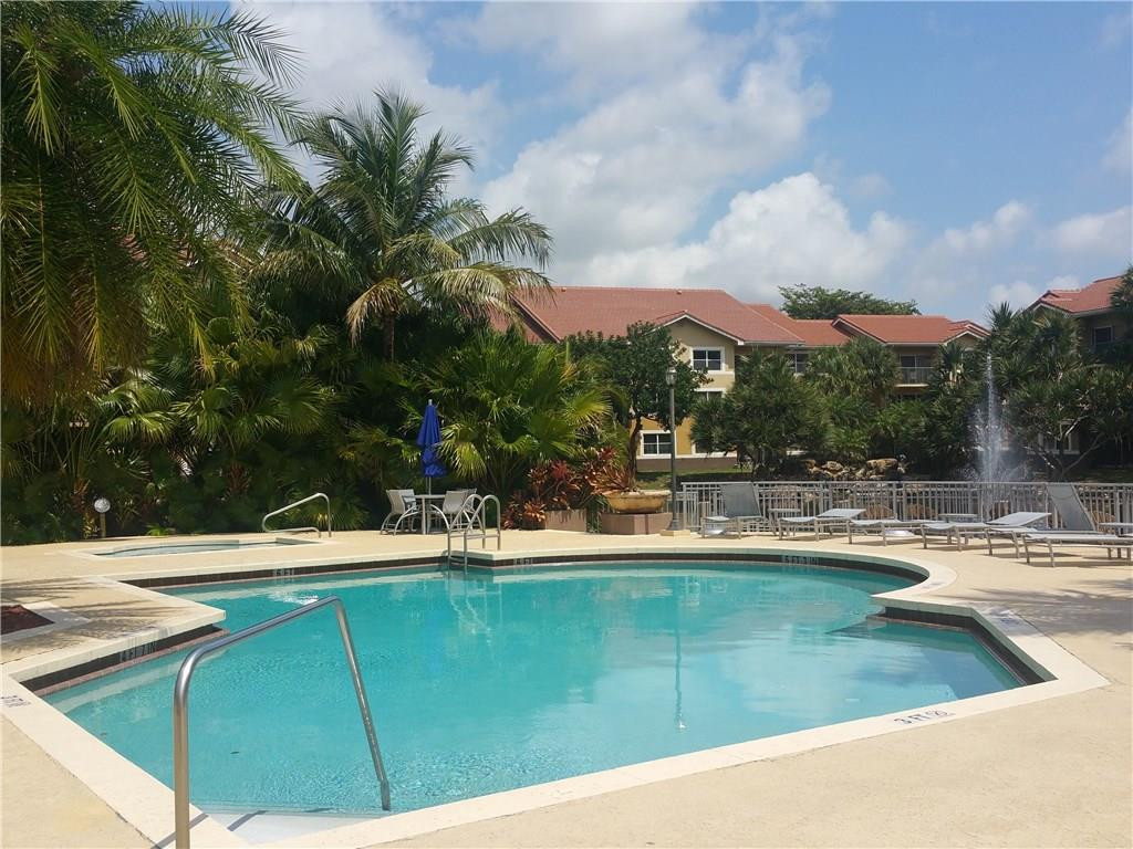 9001 Wiles Road, Unit 206 Coral Springs, FL 33067 - Photo 5 of 14 a view of a swimming pool with a patio