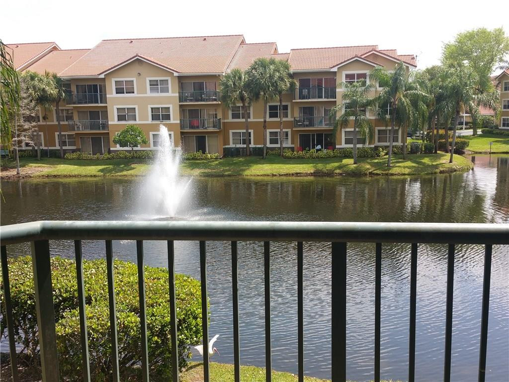 9001 Wiles Road, Unit 206 Coral Springs, FL 33067 - Photo 6 of 14 a view of a large building with a yard