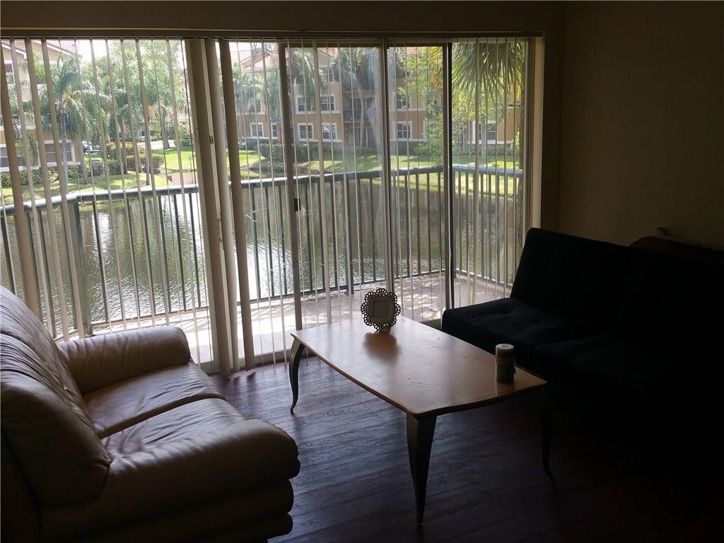 9001 Wiles Road, Unit 206 Coral Springs, FL 33067 - Photo 9 of 14 a living room with furniture and a window